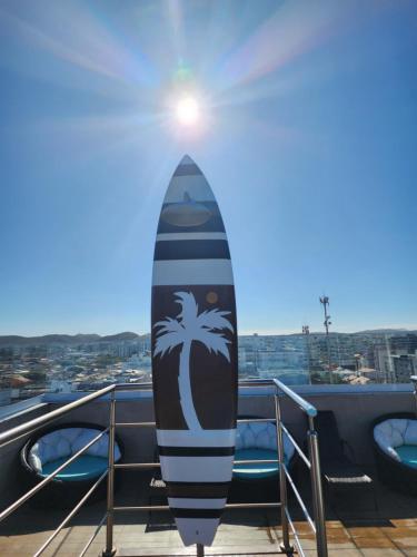 a surfboard is standing on a rack on a balcony at Paradiso Corporate in Cabo Frio