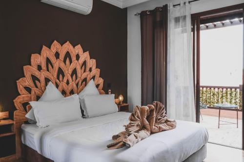 um quarto com uma cama grande e uma cabeceira em madeira em Magnifiaue appart em Marrakech