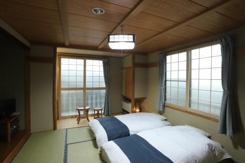 Ένα ή περισσότερα κρεβάτια σε δωμάτιο στο Oyado Uchidaya