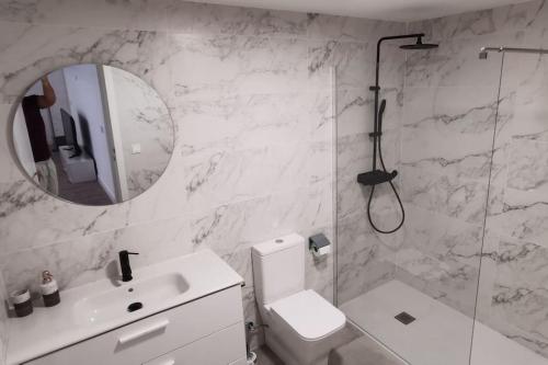 uma casa de banho com um WC, um lavatório e um espelho. em Piso lujo 2 habitaciones (1) em Las Rozas de Madrid