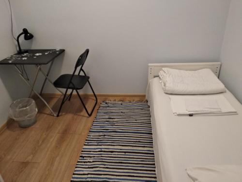 a small room with a bed and a desk and a rug at Weekly Hostel - for Solo long term travelers in Tallinn