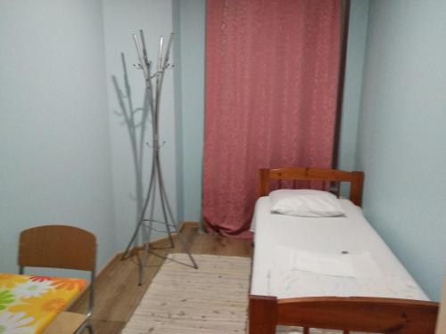 a small room with a small bed and a tripod at Weekly Hostel - for Solo long term travelers in Tallinn