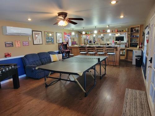a living room with a ping pong table and a kitchen at Parker Strip pool house with game room! in Parker