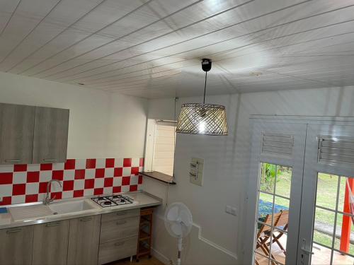 een keuken met een rood en wit geruit plafond bij Residence Les Palmiers in La Trinité