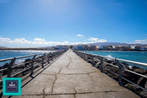 a walkway over the water on a pier at Mara 2 Playa del Burrero junto al mar, wifi gratis in Ingenio