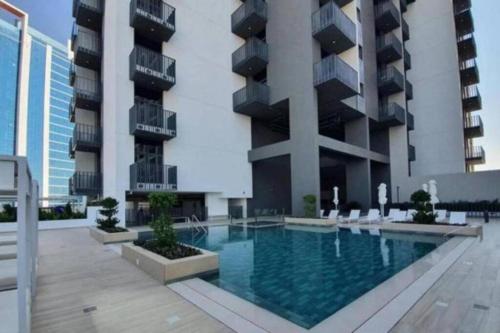 a swimming pool in front of a building at 1bdr in Belgravia Heights - JVC - Dubai in Dubai