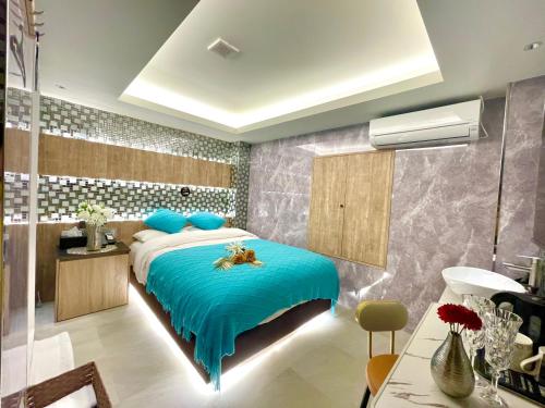 a bedroom with a bed with a blue comforter at 上野Bellaホテル in Tokyo