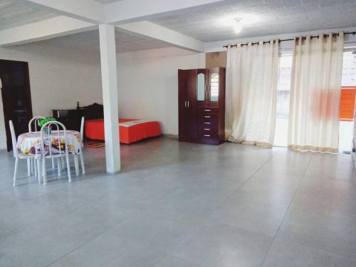 Cette chambre comprend un lit, une table et des chaises. dans l'établissement Loft privativo em Ouro Preto., à Ouro Preto