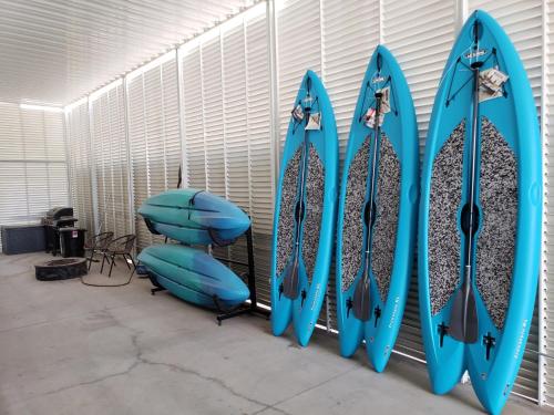 eine Gruppe blauer Surfbretter, die an einer Wand hängen in der Unterkunft Welcome to Sand Trap! Covered boat or RV parking! in Parker