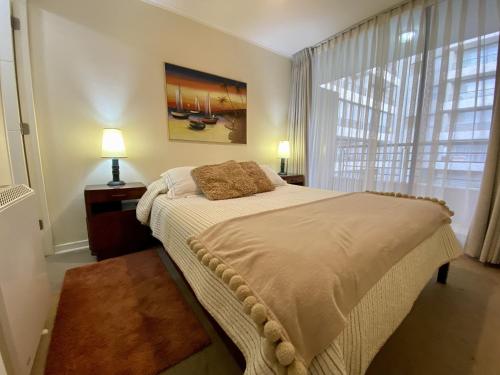 Un dormitorio con una cama grande y una ventana en Urbano Sun City - Viña del Mar, en Viña del Mar