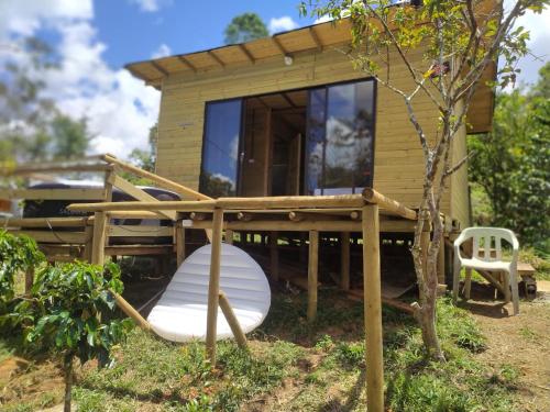 ein kleines Haus mit einer Veranda und einem Stuhl in der Unterkunft Natural Descanso in Carolina del Principe