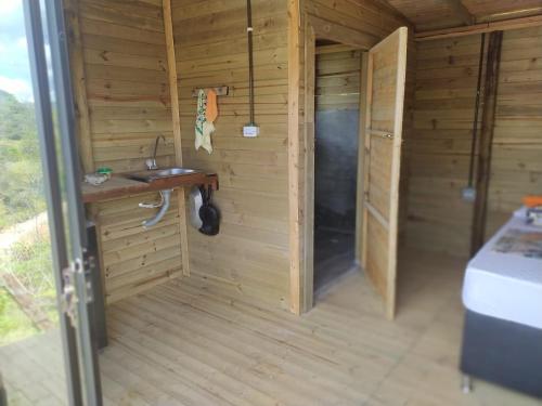 um quarto em madeira com um lavatório e uma casa de banho em Natural Descanso em Carolina del Principe