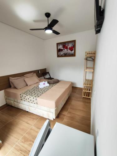a bedroom with a bed and a ceiling fan at Aparecida Akuto's Pousada in Aparecida
