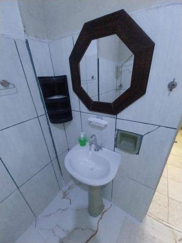 a bathroom with a sink and a mirror at Aparecida Akuto's Pousada in Aparecida