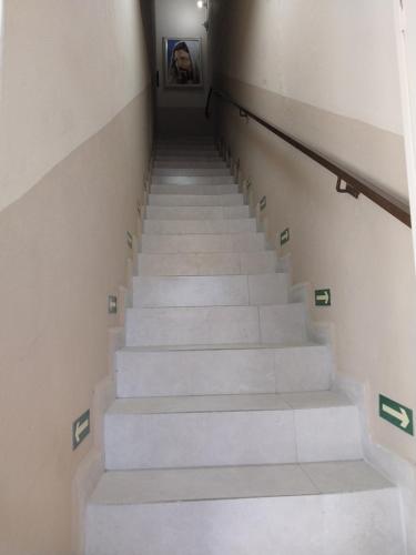 a stairway with white stairs with a person in the mirror at Aparecida Akuto's Pousada in Aparecida
