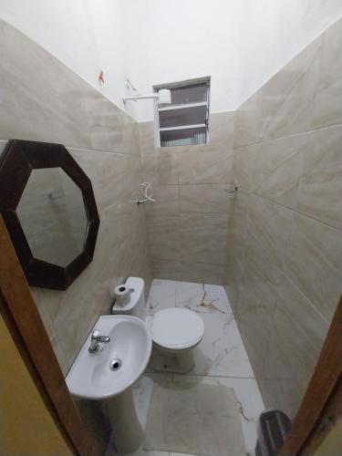 a bathroom with a sink and a toilet and a mirror at Aparecida Akuto's Pousada in Aparecida