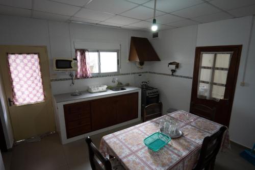 uma pequena cozinha com uma mesa com uma toalha de mesa em Casa amueblada en centro de Minas, Lavalleja em Minas