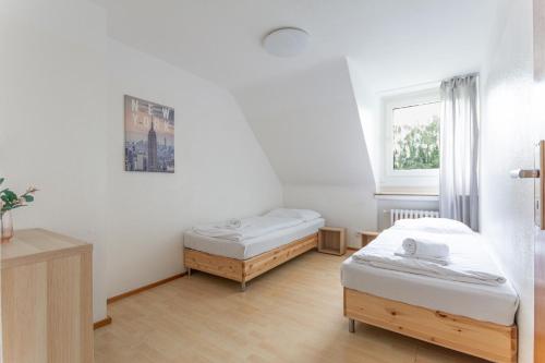 een kamer met 2 bedden en een raam bij T&K Apartments - 3 Room Apartment in Mülheim an der Ruhr