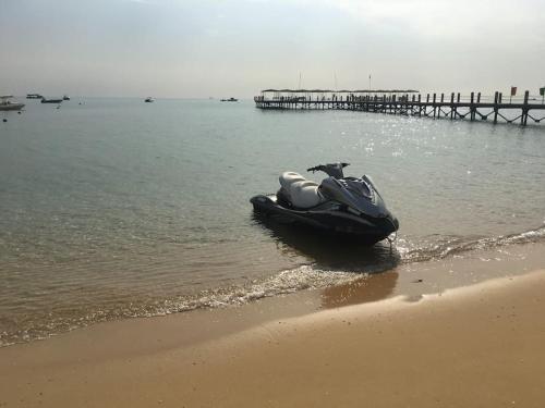 un motoscafo parcheggiato sulla spiaggia accanto a un molo di 3-Brs Beachside Modern chalet Seaview & 3min walking l BBQ a Ain Sokhna
