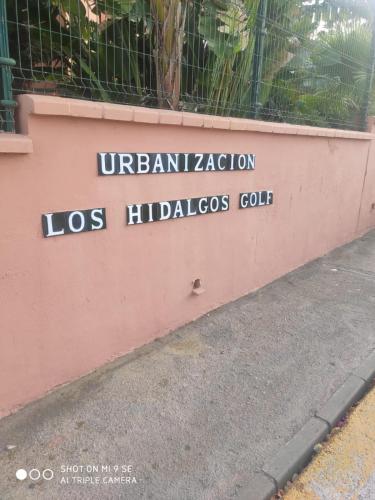 a sign on the side of a pink wall at Hidalgos SolyGolf in Manilva