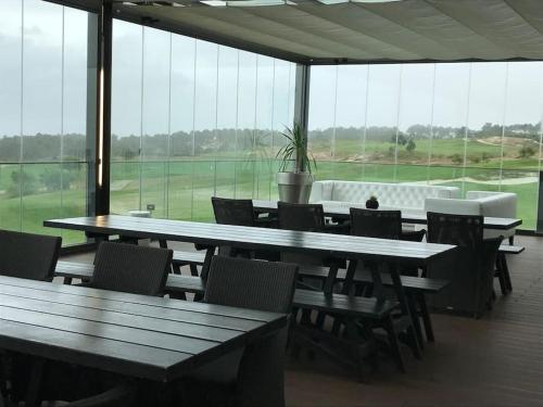 a large room with tables and chairs and windows at villa Lagoa in Óbidos