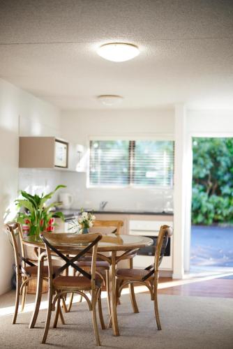 a dining room with a wooden table and chairs at Emerald Inn on Takapuna Beach in Auckland