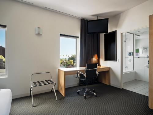 a hotel room with a desk and a chair at Saint Kilda Beach Hotel - formerly Rydges St Kilda in Melbourne