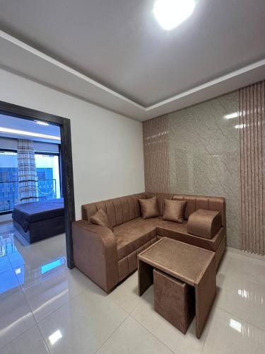 a living room with a brown couch and a table at Modern 2bedroom For Rent Abdoun in Amman