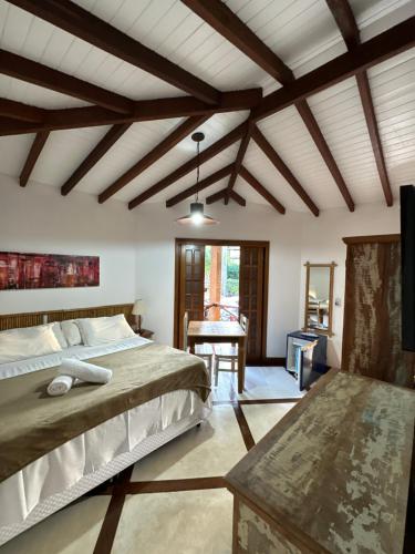 um quarto com uma cama grande e uma mesa em Pousada Villa Nina em Ilhabela
