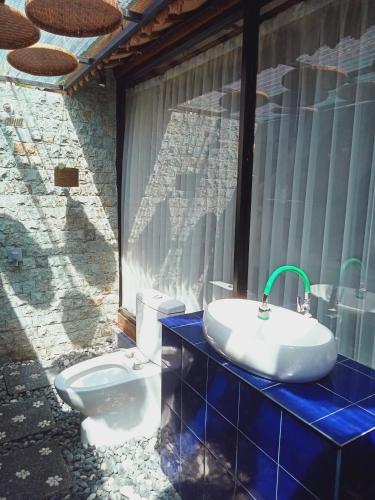 y baño con lavabo y aseo. en Buratwangi Joglo House, en Kerobokan