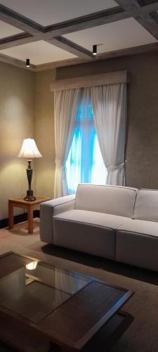 a living room with a white couch and a window at Pousada Villaggio Itália in Campos do Jordão