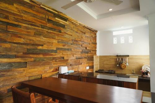 a kitchen with a table and a brick wall at Nyaman Villa Ubud in Ubud