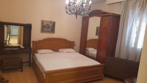 um quarto com uma cama, um espelho e um lustre em Maadi International Center Apartments no Cairo