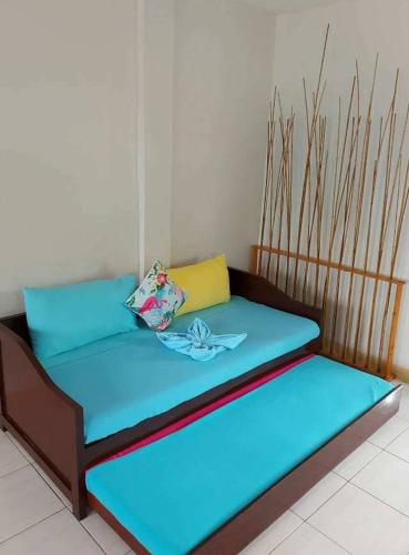 a bed with blue sheets and a pillow on it at Happy's Homestay in Boracay