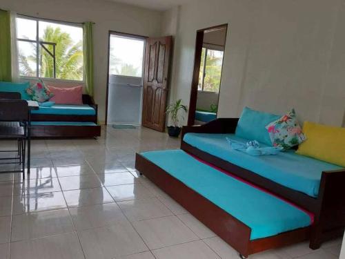 a living room with two beds in a room at Happy's Homestay in Boracay