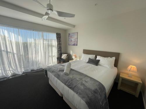 sypialnia z łóżkiem i dużym oknem w obiekcie Carters by the Sea Beachside Studio Apartments w mieście Carters Beach