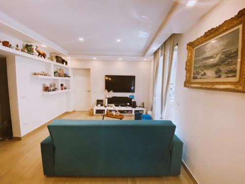a living room with a blue couch and a tv at Fifi Home in Pozzuoli