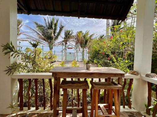 uma mesa e cadeiras num quarto com vista para o oceano em Happy's Homestay em Boracay
