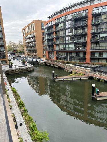 a river in a city with tall buildings at Andrei in London