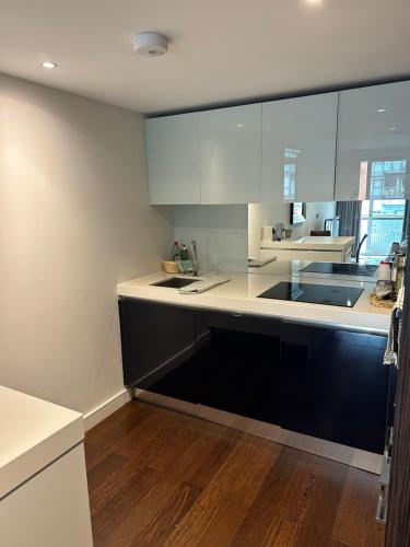 a kitchen with white cabinets and a sink at Andrei in London