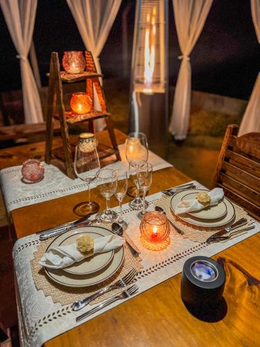 a table with plates and wine glasses on it at Camacica pousada in Miracatu
