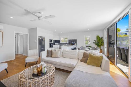 a living room with a white couch and a table at Port Macquarie Ocean Escape in Port Macquarie