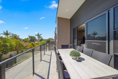 a wooden table on the balcony of a house at Port Macquarie Ocean Escape in Port Macquarie