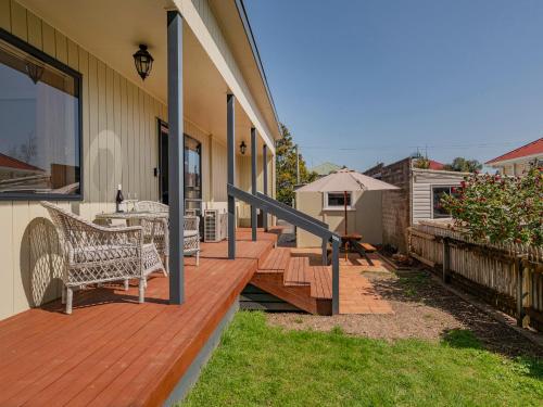 a wooden deck with chairs on a house at Gold'n Thames - Thames Holiday Home in Thames