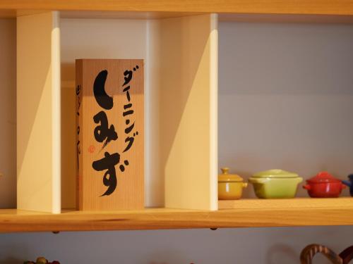 una estantería de madera con un libro. en Hotel SIMIZU en Tokamachi