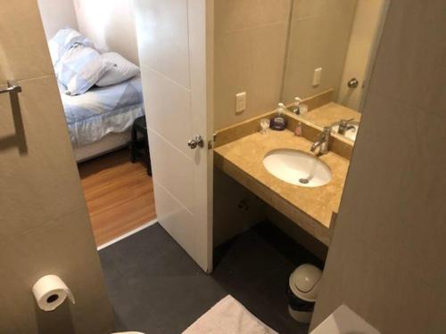un bagno con lavandino, specchio e letto di Acogedor Departamento de un cuarto en Barranco... a Lima