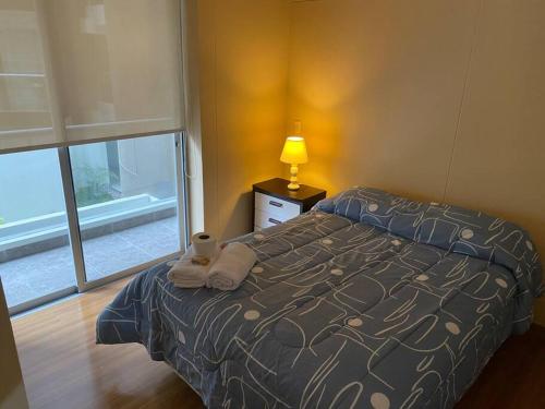 una camera con letto, lampada e finestra di Acogedor Departamento de un cuarto en Barranco... a Lima