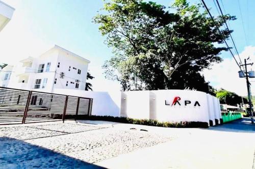 a white fence with a lrapa sign in front of a building at Lapa House 4 ( Cozy pool-3 bedrooms(LL#4) in Jacó