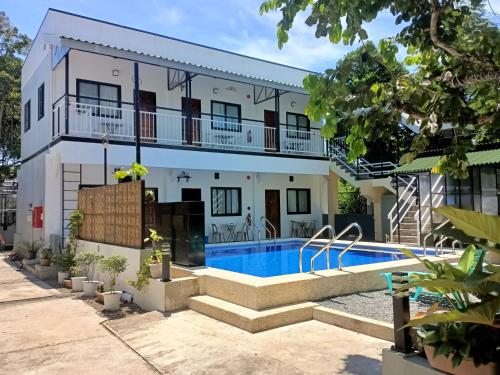 a house with a swimming pool in front of it at Alona WhiteHouses Resort in Panglao Island