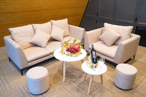 a living room with two couches and two tables with drinks at Sunny Garden Riverside Hotel Ninh Binh in Ninh Binh